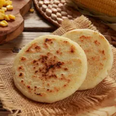 Deux arepas dorées, garnies de maïs, sur une toile de jute. Un délice à déguster !