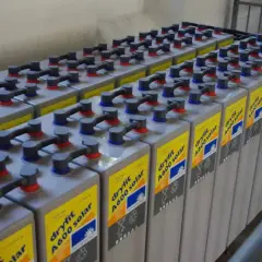 Rzędy baterii do fotowoltaiki, połączonych kablami. Każda bateria ma żółtą etykietę z napisem "dryfit A600 solar".