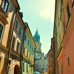 Ulica w Lublinie z kolorowymi kamienicami i wieżą. Może to być początek przygody w parku rozrywki Lublin.