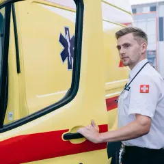 Ratownik medyczny przy karetce, gotowy do akcji. To on często jako pierwszy stwierdza zgon w domu.