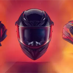Tres cascos de moto flotan: uno de cross negro y naranja, uno integral negro con visor rojo, y uno deportivo rojo y negro.