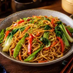 Pyszny makaron chow mein z warzywami, posypany sezamem i szczypiorkiem. Idealny na szybki obiad.