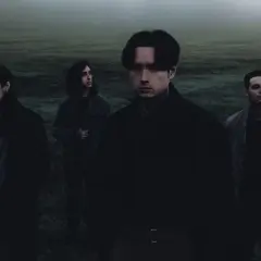 Czterech mężczyzn w mrocznym, mglistym krajobrazie. Ich postawy sugerują niepokój, jakby zbliżały się **bad omens polska**.