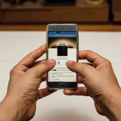 Ręce trzymające smartfon z profilem na Facebooku. Szukasz informacji, jak usunąć relacje na FB?