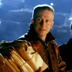 Trzej mężczyźni w nocnej scenerii, jeden z nich niesie pakunek. Scena z jednego z kultowych **Władysław Pasikowski filmy**.