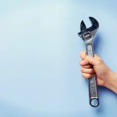 Mano sujetando una llave inglesa ajustable, útil para saber el par de apriete de un tornillo.