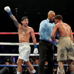 Boxer with arm raised, referee between two fighters. A majority decision in boxing means two of the three judges scored the fight for one boxer.