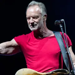 Sting w czerwonej koszulce, z gitarą i mikrofonem, jakby śpiewał o swoich dzieciach.