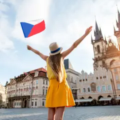 Kobieta z flagą Czech na Rynku Staromiejskim w Pradze. Słowa po czesku, radość podróżowania.