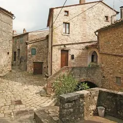 Un vicolo acciottolato a Semproniano, con case in pietra e archi. Un luogo incantevole da esplorare per scoprire cosa vedere.