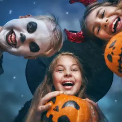 Barn med pumpor och utklädnader för ett rysligt halloween kalas.