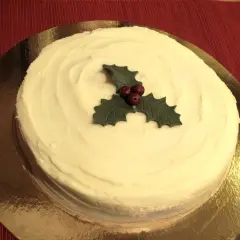 En krämig tårta med vit glasyr, dekorerad med en julstjärna av marsipan. Perfekt för julfikat!