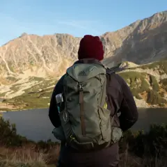 Turysta z plecakiem Gregory Jade 33 podziwia jesienny krajobraz górski z jeziorem.