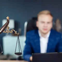 Waga sprawiedliwości i mężczyzna w garniturze. Czy czysty BIK to gwarancja, czy odmowa kredytu?