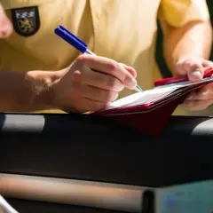 Policjant spisuje mandaty w Niemczech. Kierowca pokazuje dokumenty.