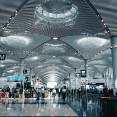 Nowoczesny terminal lotniska z ludźmi i bagażami. Zastanawiasz się, ile wcześnie być na lotnisku? Tutaj jest tłoczno.