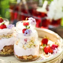 En härlig sommardessert i glasburkar, en himmelsk jordgubbstårta med fluffig kräm och färska bär.