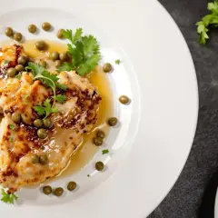 Délicieuse aile de raie poêlée au beurre, nappée d'une sauce légère et parsemée de câpres et de persil frais. Un plat savoureux.