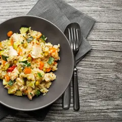 Piatto di riso con pollo e verdure miste, un esempio di alimentazione funzionale per un pasto completo e nutriente.
