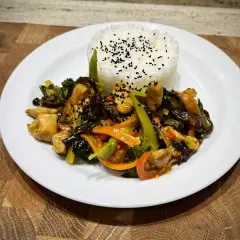 Pyszny kurczak w pięciu smakach z ryżem i warzywami, posypany czarnym sezamem.