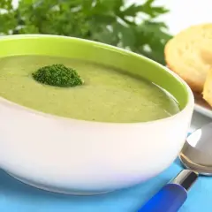 Zielona, kremowa zupka dla niemowlaka z brokułem, podana z grzankami.