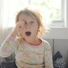 Małe dziecko zaspane, z otwartymi ustami, jakby miało nieprzyjemny zapach z ust dziecka.