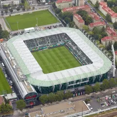 Widok z lotu ptaka na Allianz Stadion, gdzie zielona murawa i trybuny wypełnione kibicami czekają na mecz.