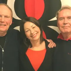 Sten Nilsson med familj, glada leenden och en röd bakgrund.