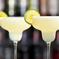 Två frostiga margaritas med saltkant och lime. Perfekt för en varm sommardag.