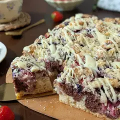 Puszyste ciasto z owocami na oleju i kruszonką, polane białą czekoladą. Idealne na deser z kawą.