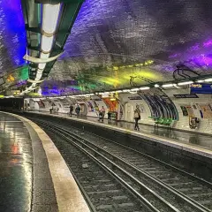 Le quai du métro Arts et Métiers, illuminé par des lumières colorées rappelant un atelier des lumières, attend les voyageurs.