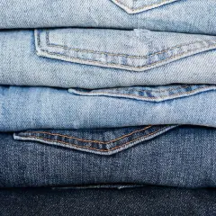 Stos jasnych i ciemnych jeansów. Czy to firma Replay?