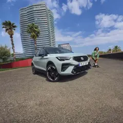 En Seat Arona står parkerad vid en strandpromenad med en person på skateboard i bakgrunden. Inga problem med denna bil.