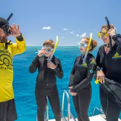 Rodzina w strojach do snorkelingu na łodzi, gotowa do zwiedzania Wielkiej Rafy Koralowej.