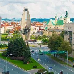 Widok na pomnik, kościół i ruchliwe skrzyżowanie w Lublinie.