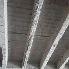 Unterseite einer stahlbeton rippendecke mit sichtbaren Rippen und Bewehrung.