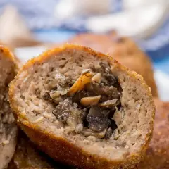 Kotlety mielone z pieczarkami, przekrojone na pół, ukazujące soczyste, aromatyczne wnętrze.