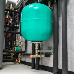 Réservoir d'expansion vert vif, partie d'un système de plomberie avec une pompe booster.