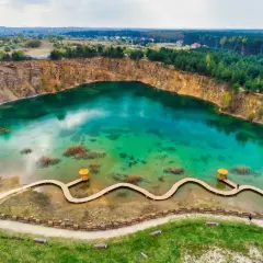 Nietypowe miejsca w Polsce na weekend: turkusowe jezioro w kamieniołomie z drewnianą kładką i altanką. Idealne na relaks.