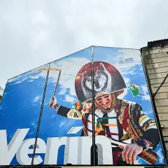 Mural en Verín con un lobo y un personaje de carnaval. ¡Descubre qué ver en Verín y su cultura!