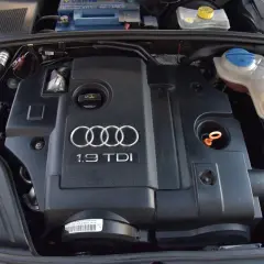 Silnik 1.9 TDI Audi z widocznym logo i oznaczeniem. Widać elementy układu chłodzenia i akumulator.