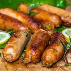Złociste kiełbaski dojrzewające, idealne do grillowania lub smażenia. Podane z cytryną, pomidorkami i rozmarynem. Pyszne i proste w przygotowaniu!