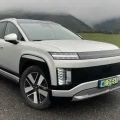 Srebrny Hyundai Ioniq 9 na tle mglistych gór i zielonych łąk.
