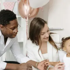 Famille célébrant la tradition du baptême. Un père, une mère et leur bébé, entourés de décorations festives.