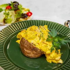 En saftig bakad potatis med en krämig kycklingfyllning, toppad med färsk persilja. Serveras med en fräsch sallad.