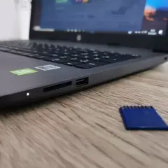 Obok laptopa leży niebieska karta pamięci. Dysk jest zabezpieczony przed zapisem, co uniemożliwia modyfikację danych.