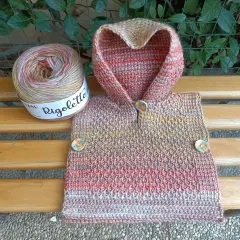 Uncinetto magico per un poncho colorato, con gomitolo Rigoletto e bottoni decorativi.
