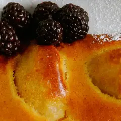 Delicioso postre de peras al horno, cubierto con moras frescas y espolvoreado con azúcar glas.