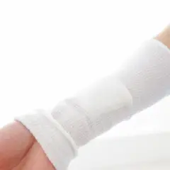 Ramię owinięte bandażem, opatrunek na ranę po operacji.