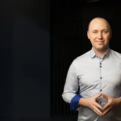 Mężczyzna w koszuli z wzorem, z dłońmi złożonymi na brzuchu. Chcesz wiedzieć, co zrobić, żeby ludzie Cię lubili?